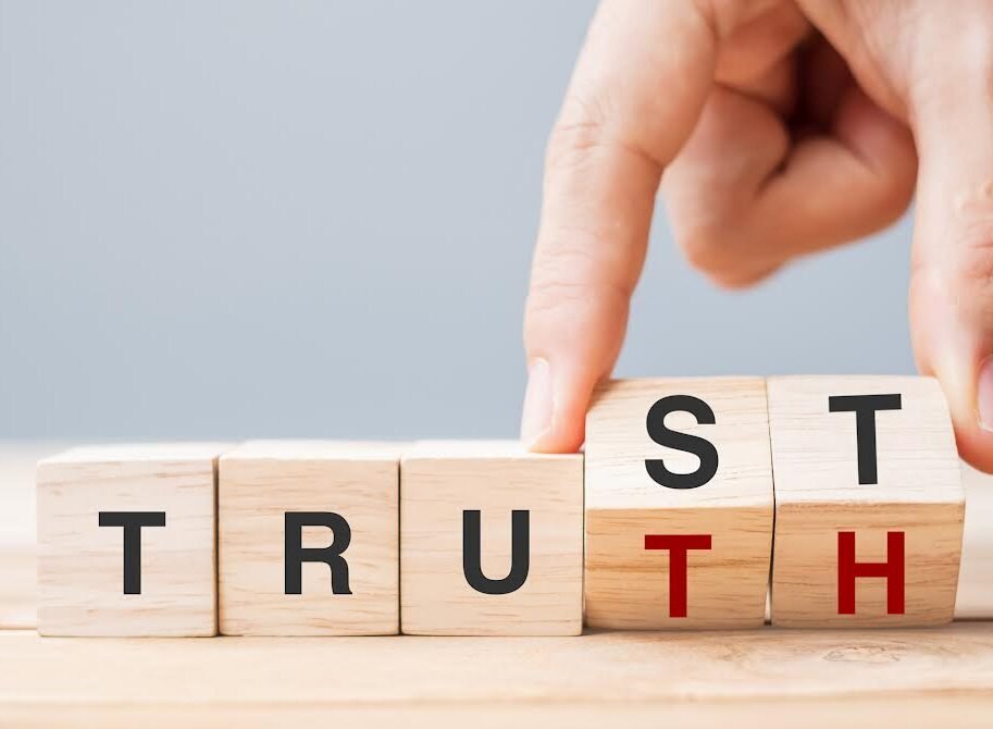 Business man hand change wooden cube block with TRUST and TRUTH business word on table background. Trustworthy, faith, beliefs and honesty concept